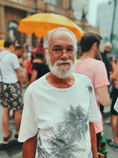 Older market trader smiling on a busy festival street